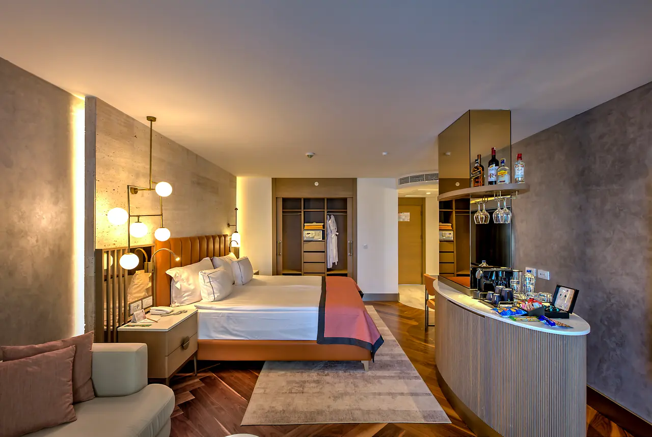 Barut Lara — Yatak odası: aydınlatmalı yatak başı ve kavisli mini bar
