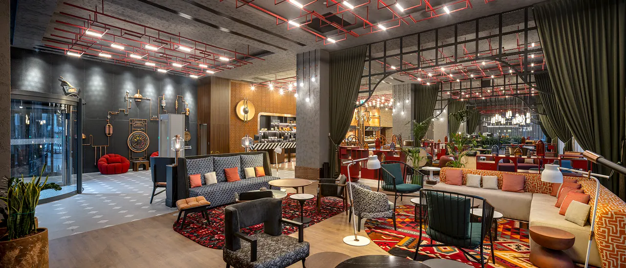 Canopy by Hilton — Lobi salonu: renkli halılar ve karışık oturma grupları
