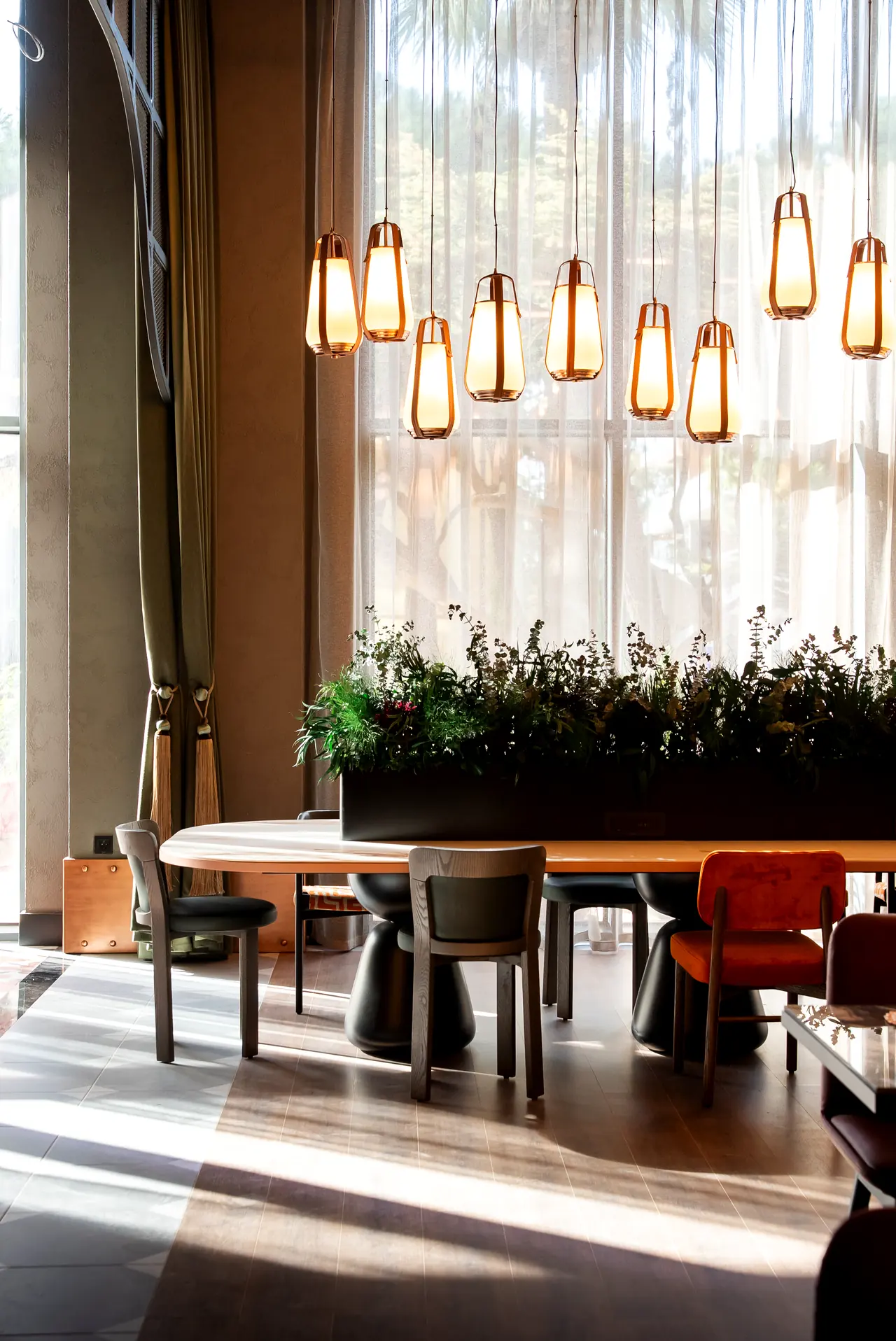 Canopy by Hilton — Sarkıt aydınlatmalı pencere önü yemek masası