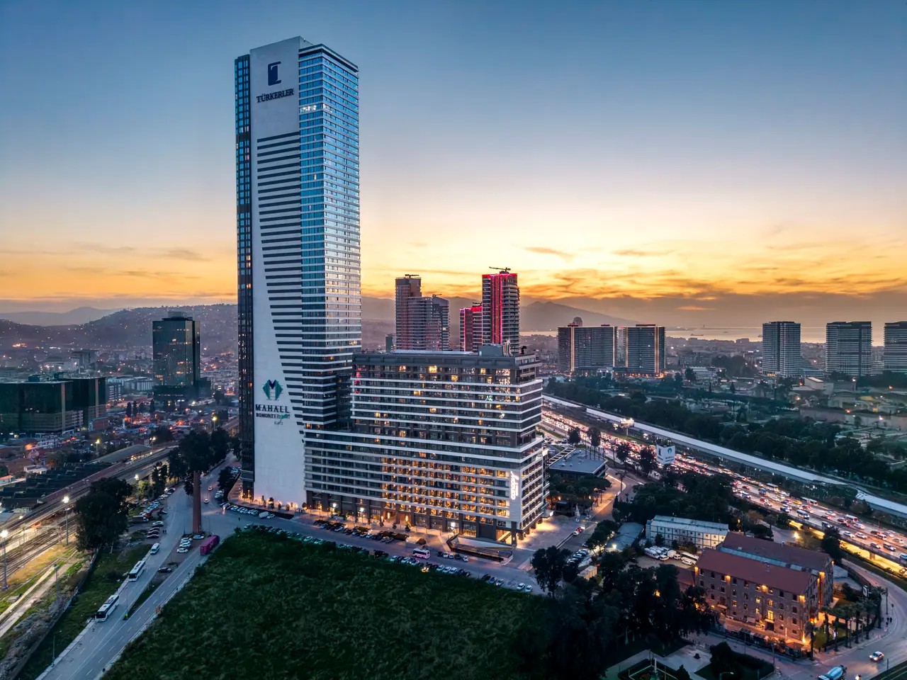Canopy by Hilton — Gün batımında otel kulesi ve şehir