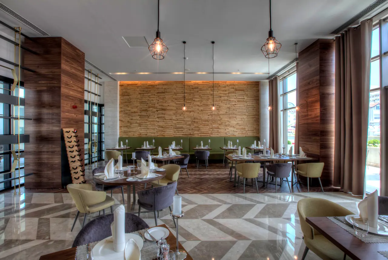 Cennet & Acanthus Barut — Restoran: taş kaplı duvar ve yuvarlak masalar