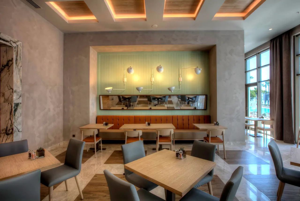Cennet & Acanthus Barut — Kafe: yeşil banket ve ahşap masalar