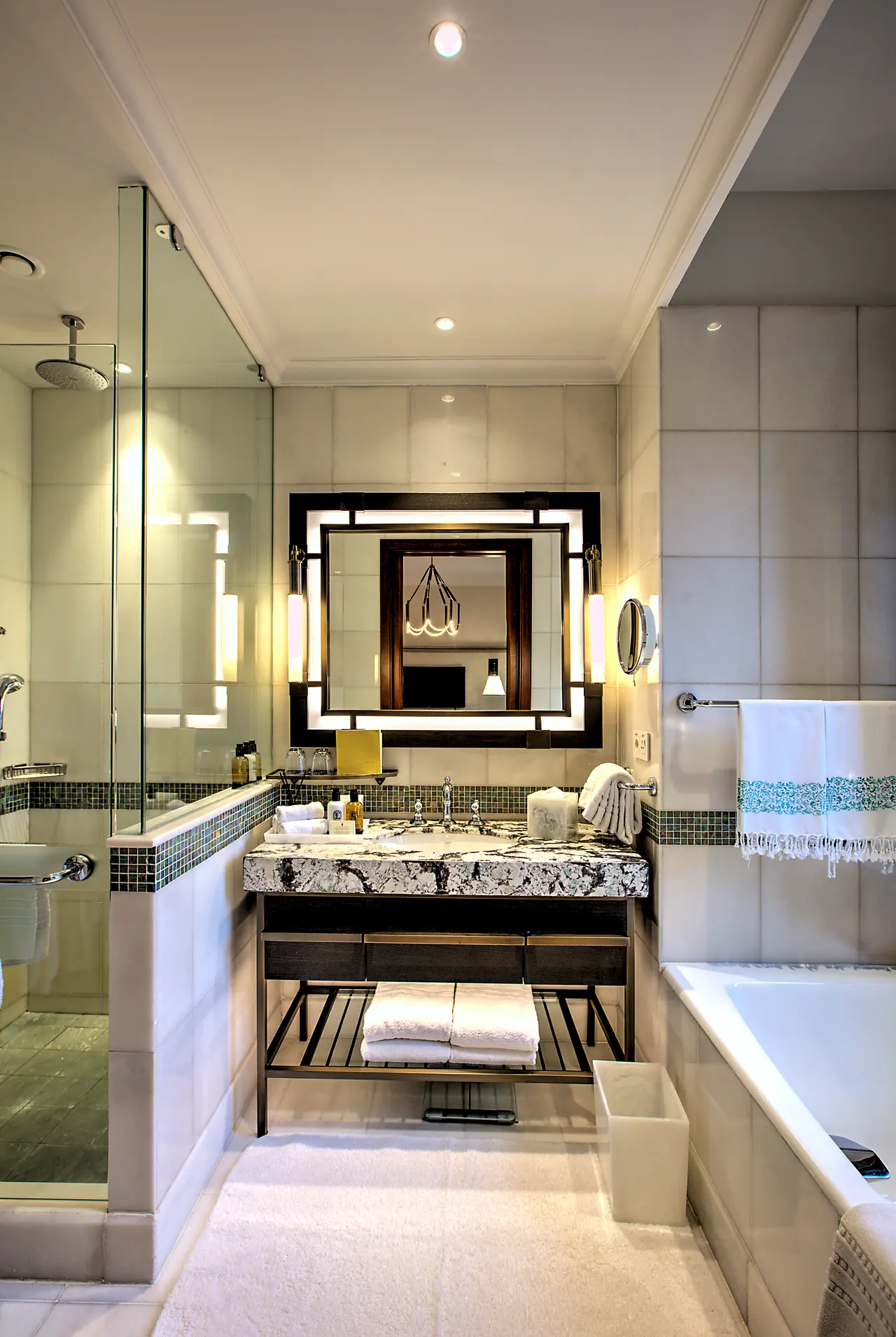 Four Seasons Hotels & Resorts — Mermer lavabo tezgâhı ve cam duşlu banyo