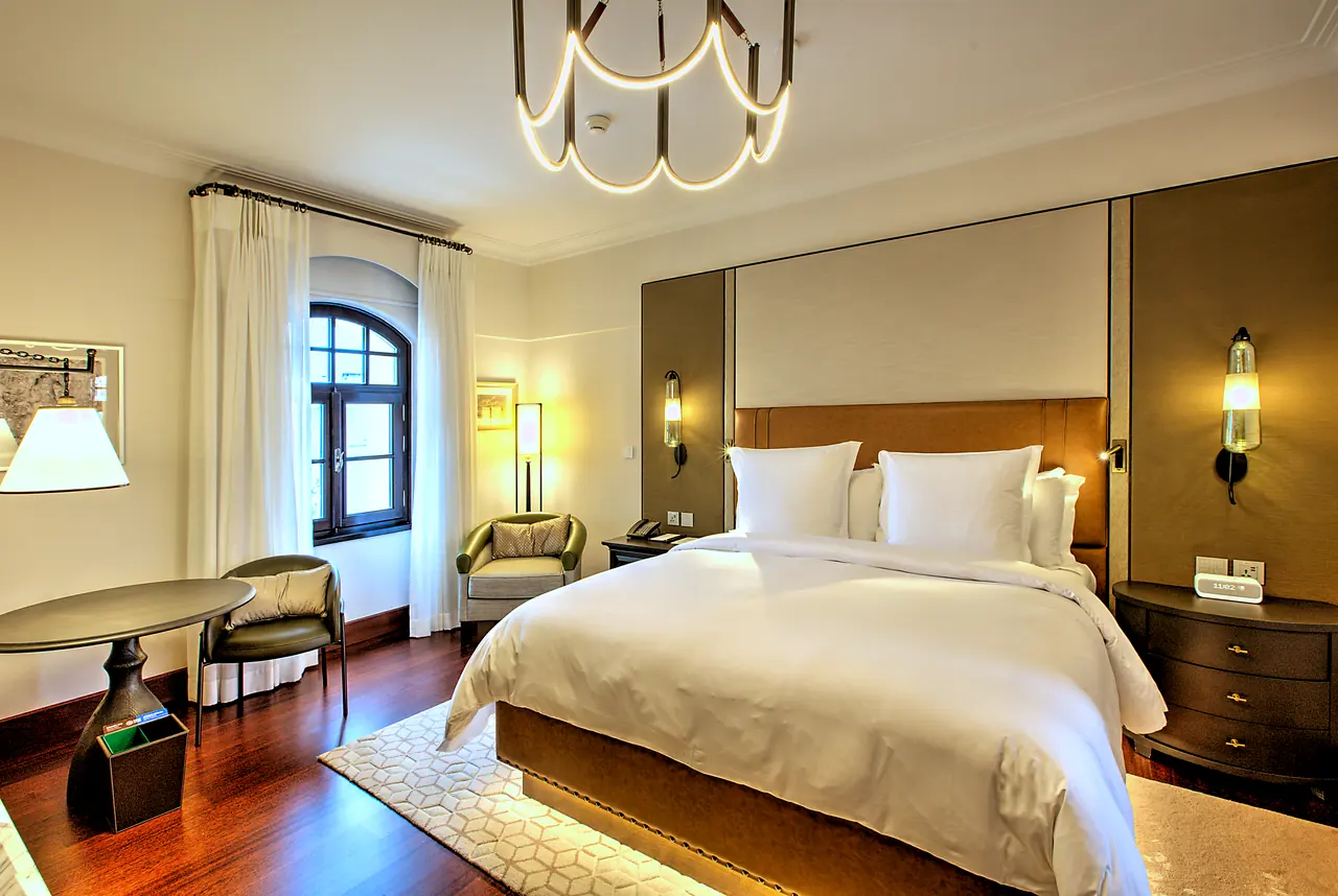 Four Seasons Hotels & Resorts — Tarihî pencereler önünde yatak ve çalışma köşesi