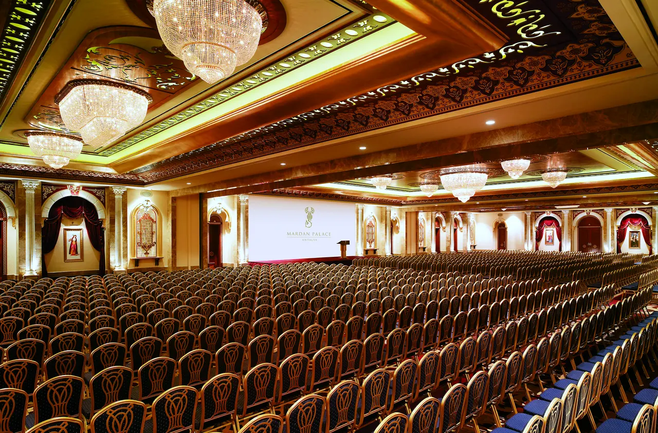 Mardan Palace — Konferans salonu: sıra sıra sandalyeler, altın tavan
