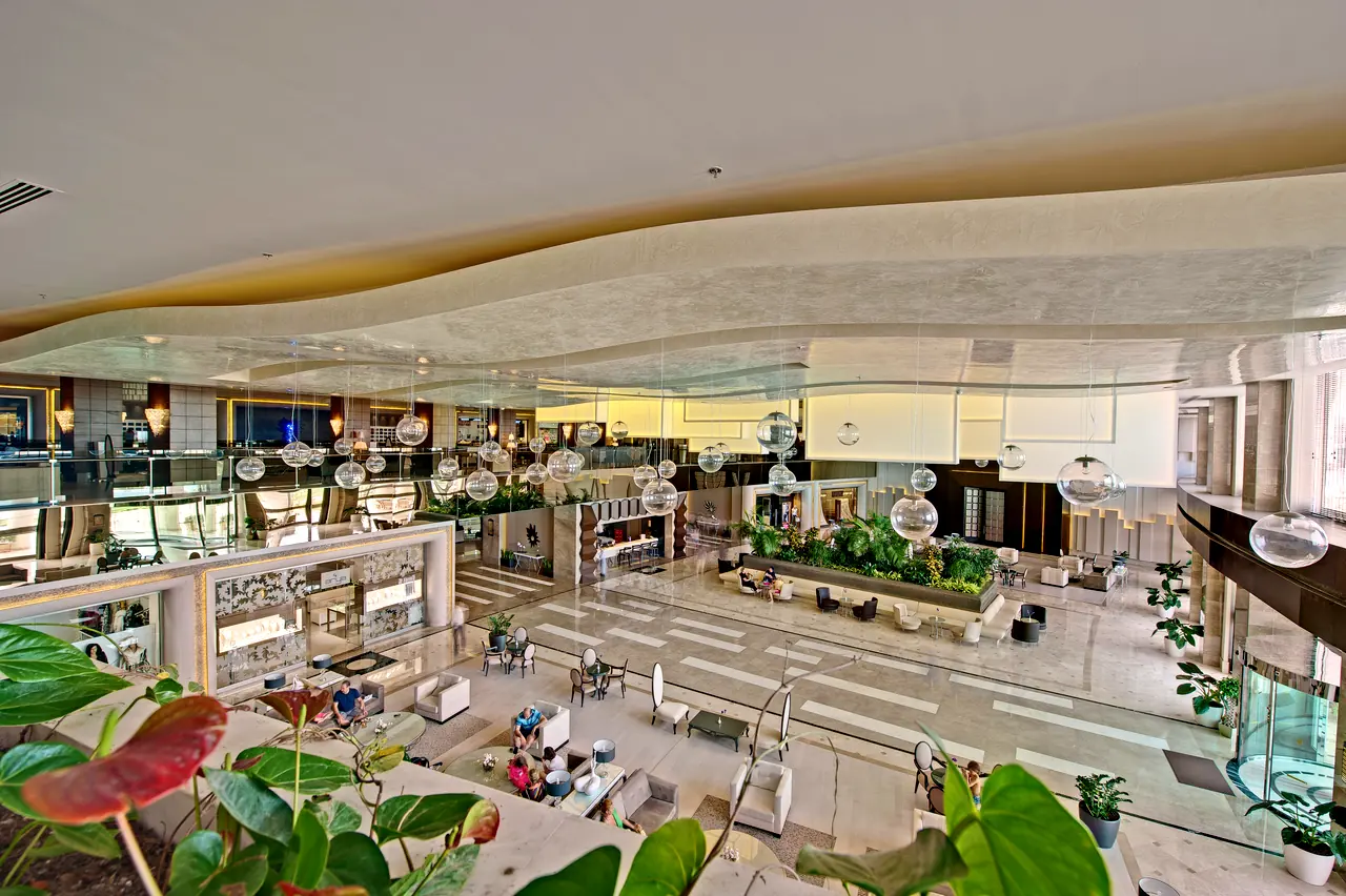 Maxx Royal Belek — Galeri katından bitkili lobiye bakış