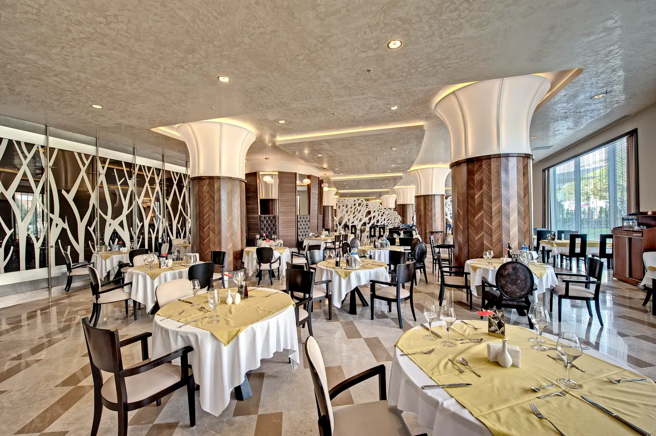 Maxx Royal Belek — Restoran: dal desenli paneller ve beyaz kolon başlıkları