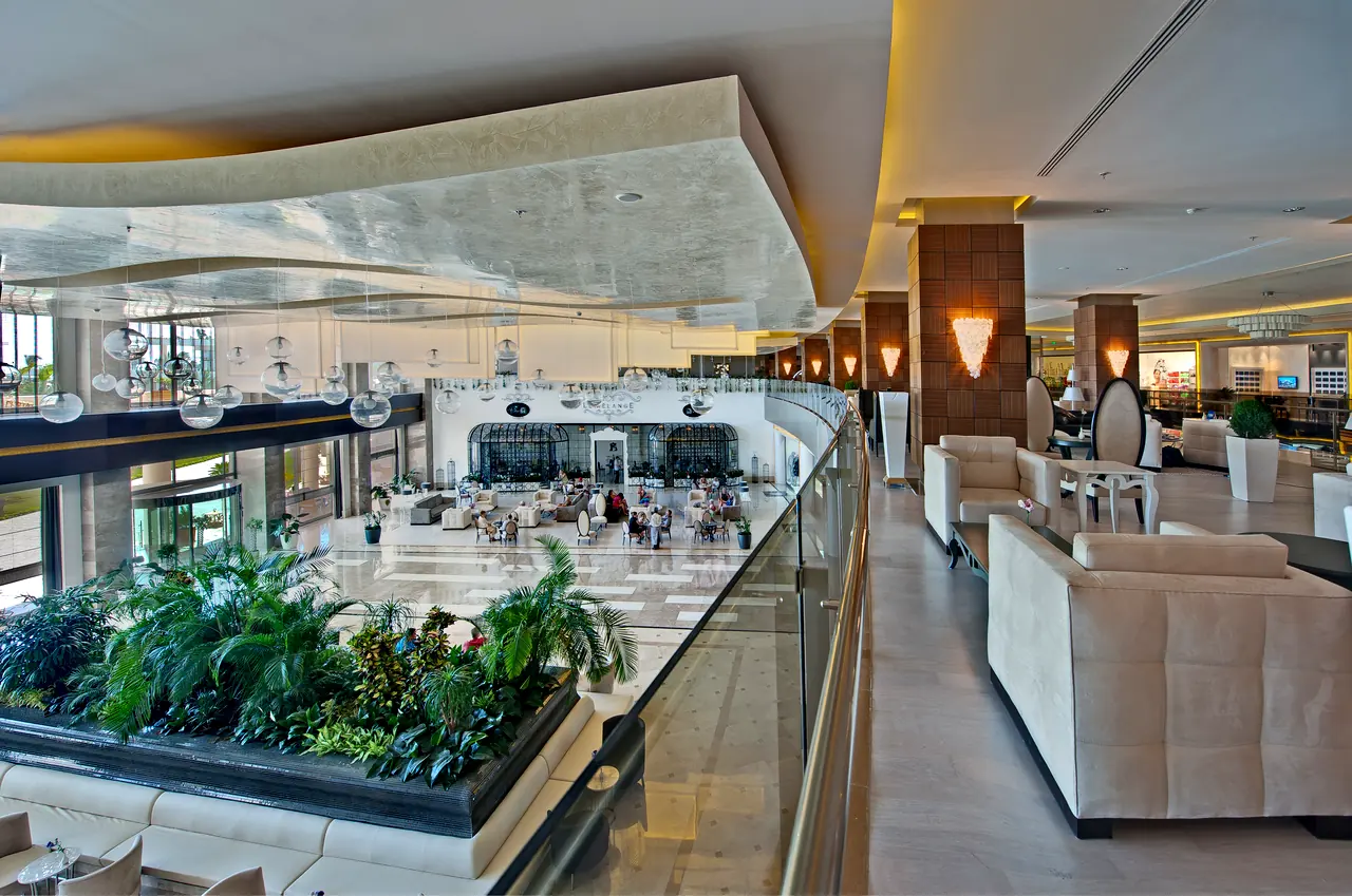 Maxx Royal Belek — Galeri katında oturma grubu ve bitki havuzu