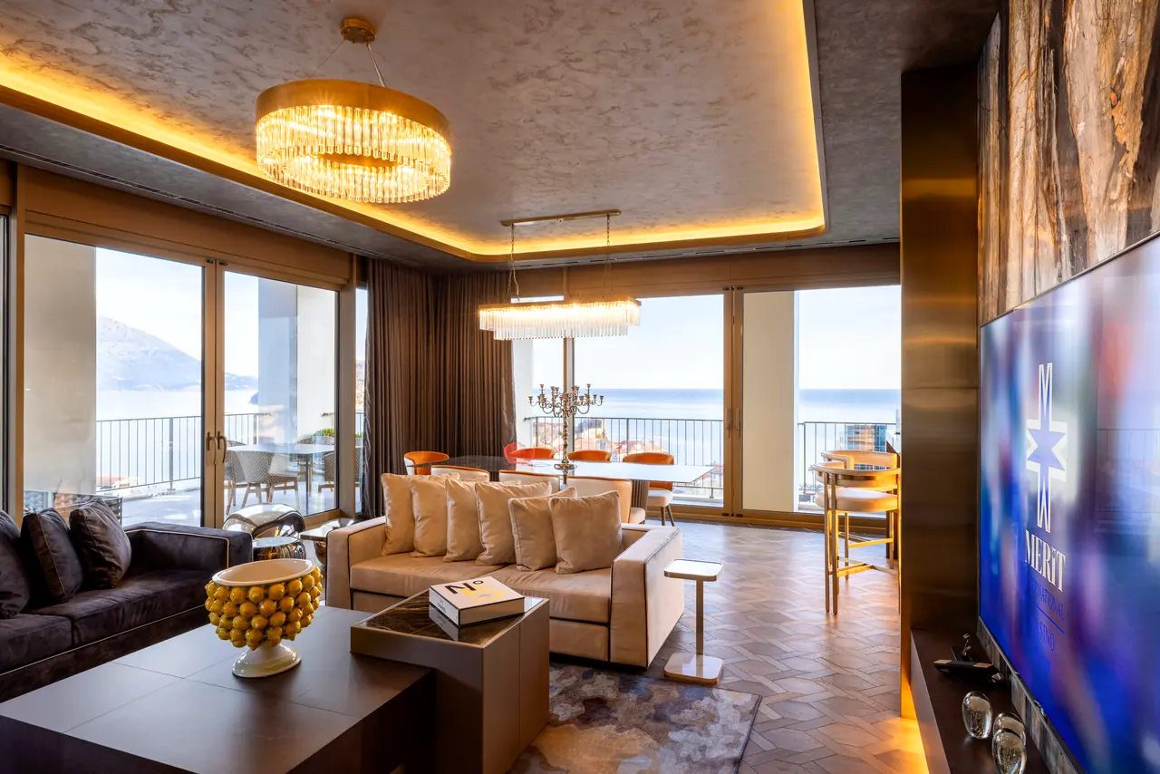 Merit Starlit Hotel Residence — Süit salonu: kristal avizeler ve deniz manzaralı pencereler