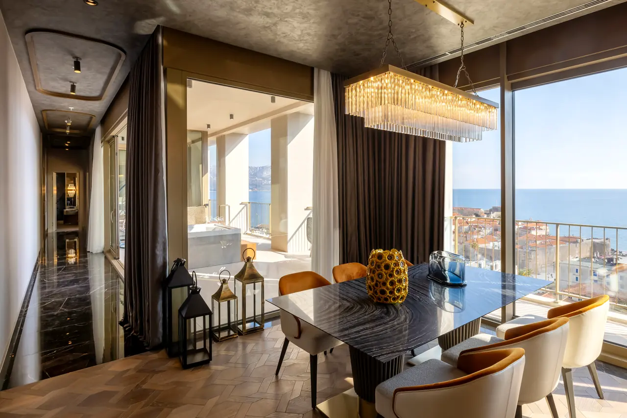 Merit Starlit Hotel Residence — Yemek masası ve deniz manzaralı balkon kapısı