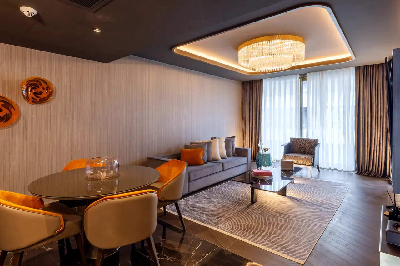 Merit Starlit Hotel Residence — Süitte yuvarlak yemek masası ve oturma grubu