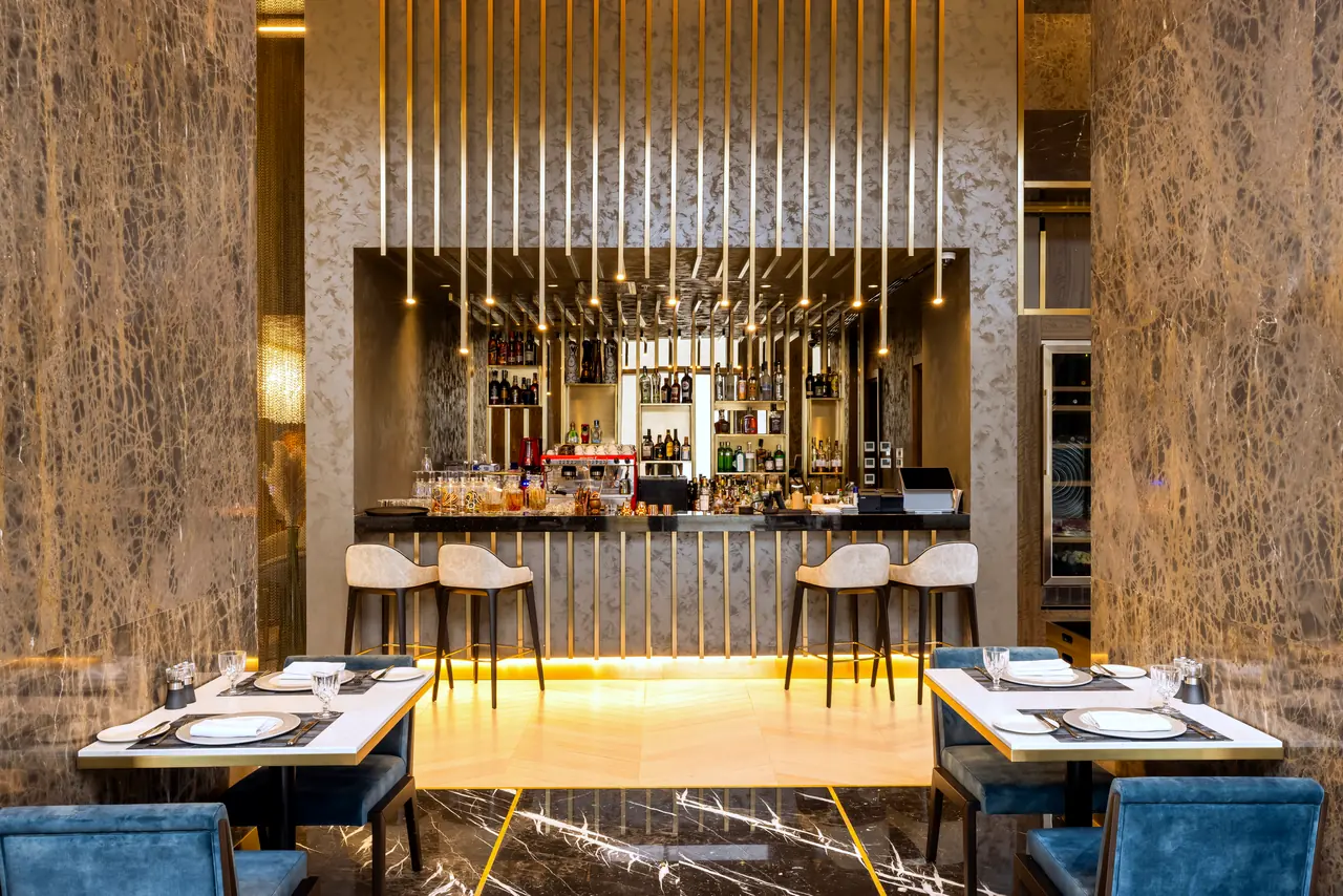 Merit Starlit Hotel Residence — Bar: pirinç çubuklu arka duvar ve masalar