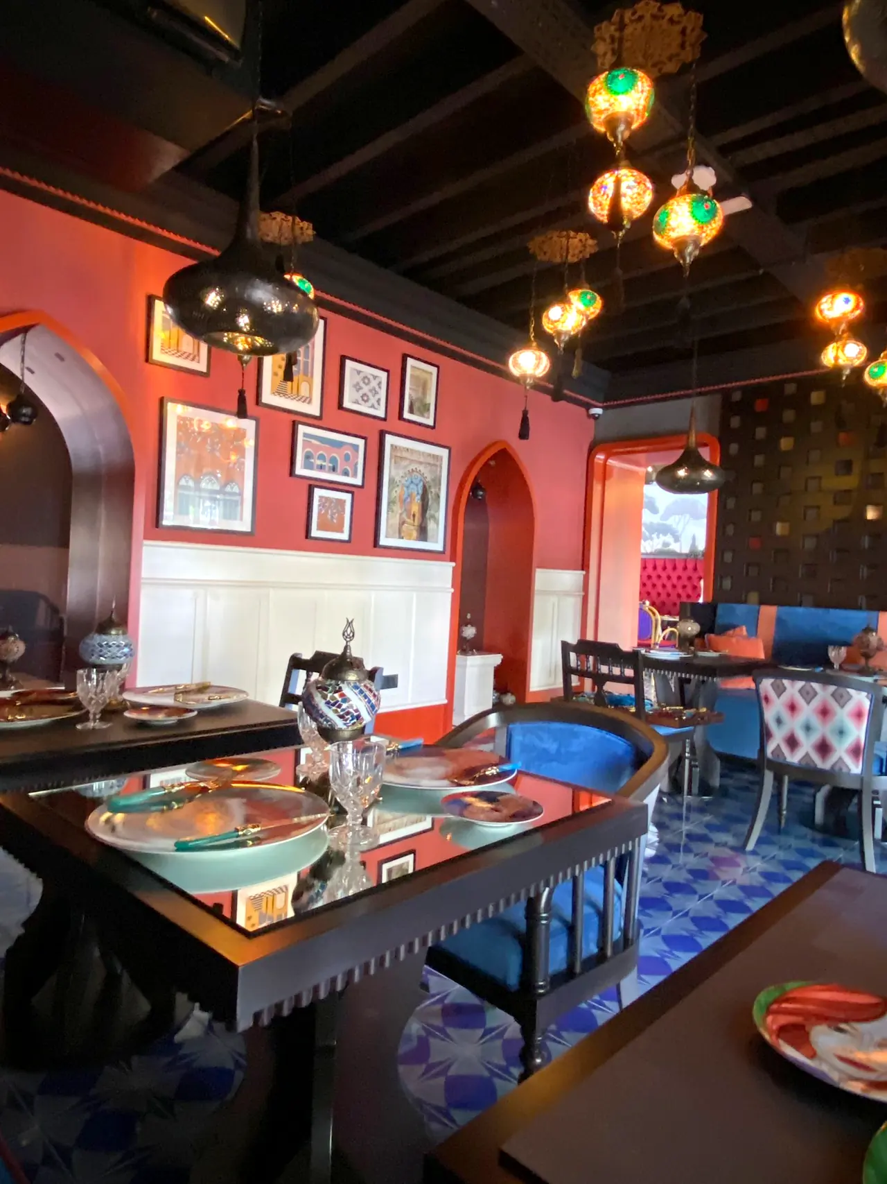 Merit Zaytoun — Kemerli nişler ve tablolarla restoran köşesi