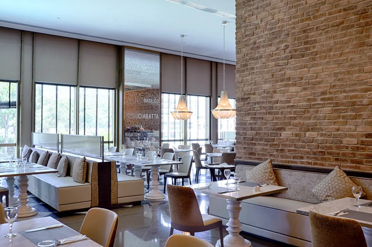 Rixos Premium Belek — Restoran: tuğla duvar, kanepeli bölmeler ve avizeler