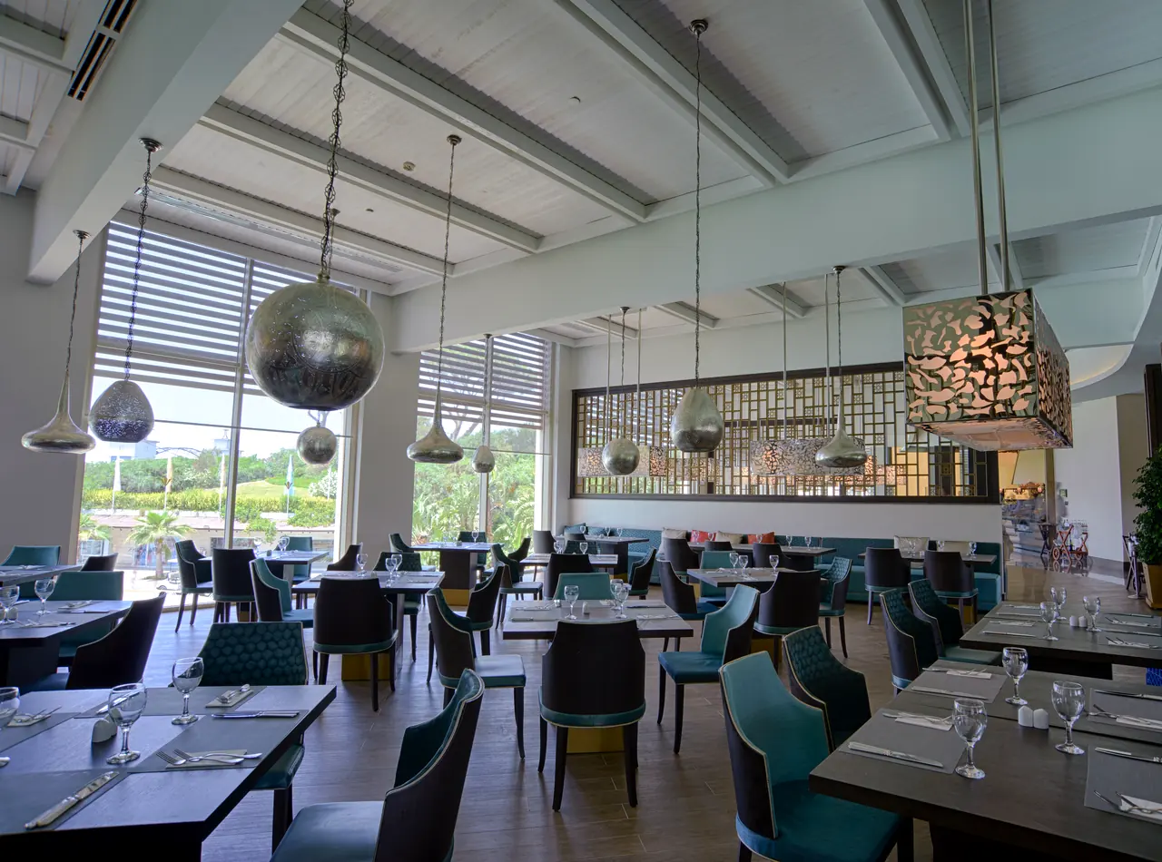 Rixos Premium Belek — Restoran: metal sarkıtlar ve bahçe manzarası