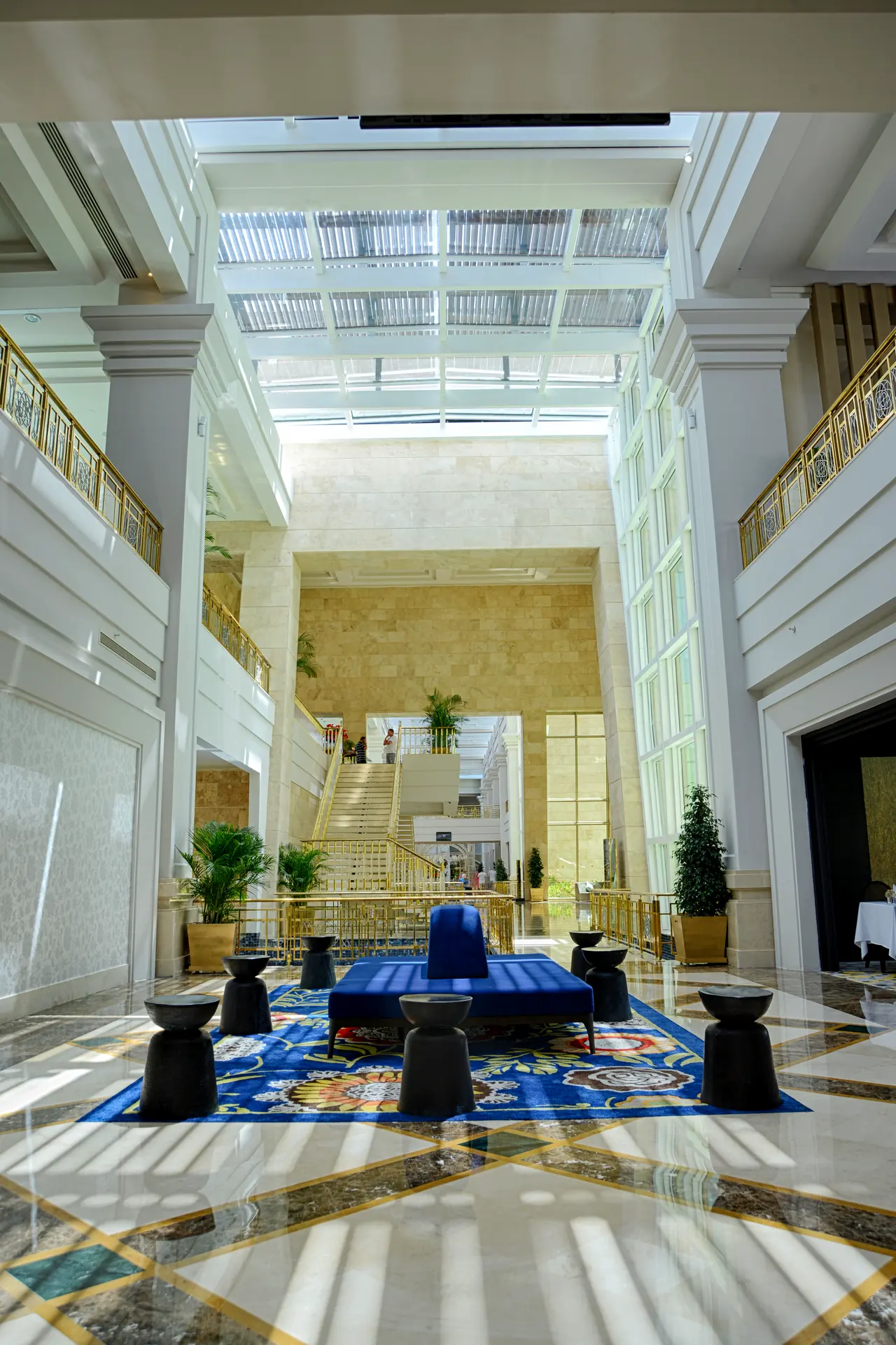 Rixos Premium Belek — Çok katlı lobi: mavi halı ve oturma grupları