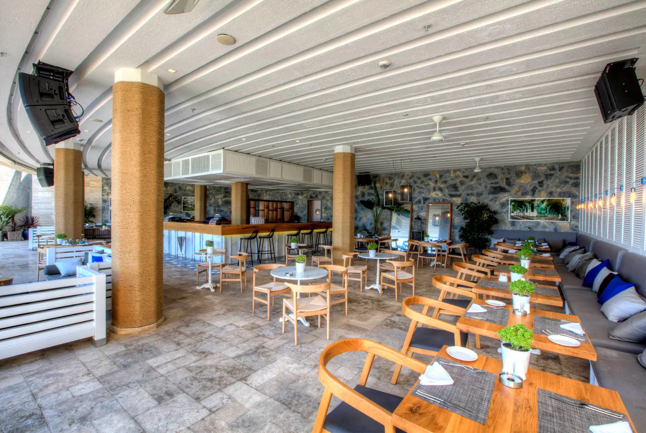 Sirene Luxury Hotel — Yarı açık restoran: taş duvar ve ahşap masalar