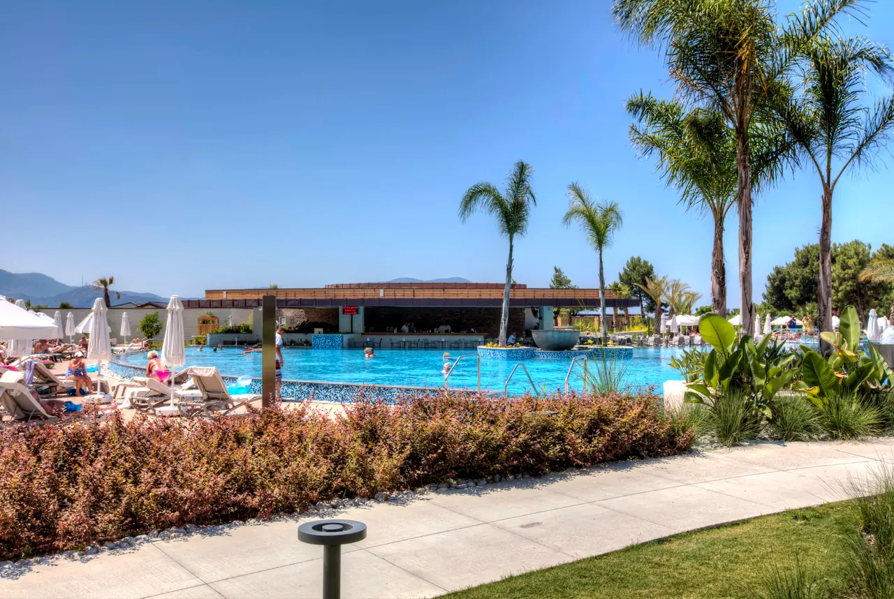 TUI Sensatori Barut — Havuz ve palmiyeli bahçe