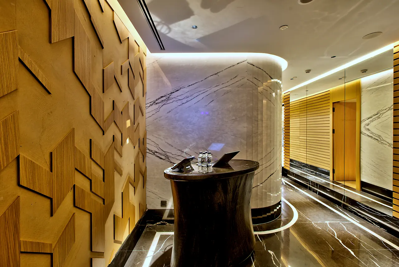 Vakko Hotel — Kavisli mermer duvar ve karşılama bankosu