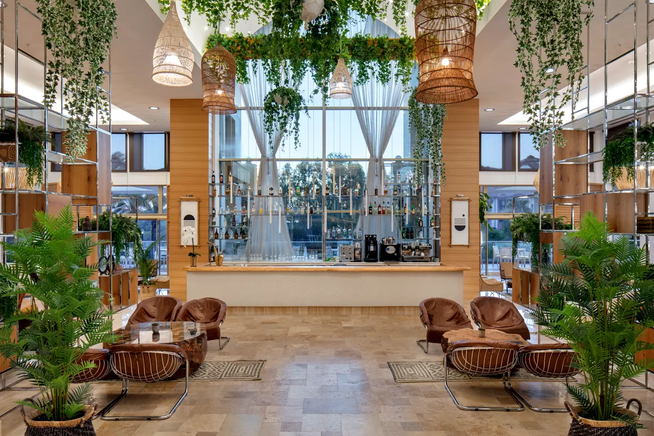 Xanthe Resort & Spa — Lobi: sarkan bitkiler, hasır avizeler ve cam cepheli bar