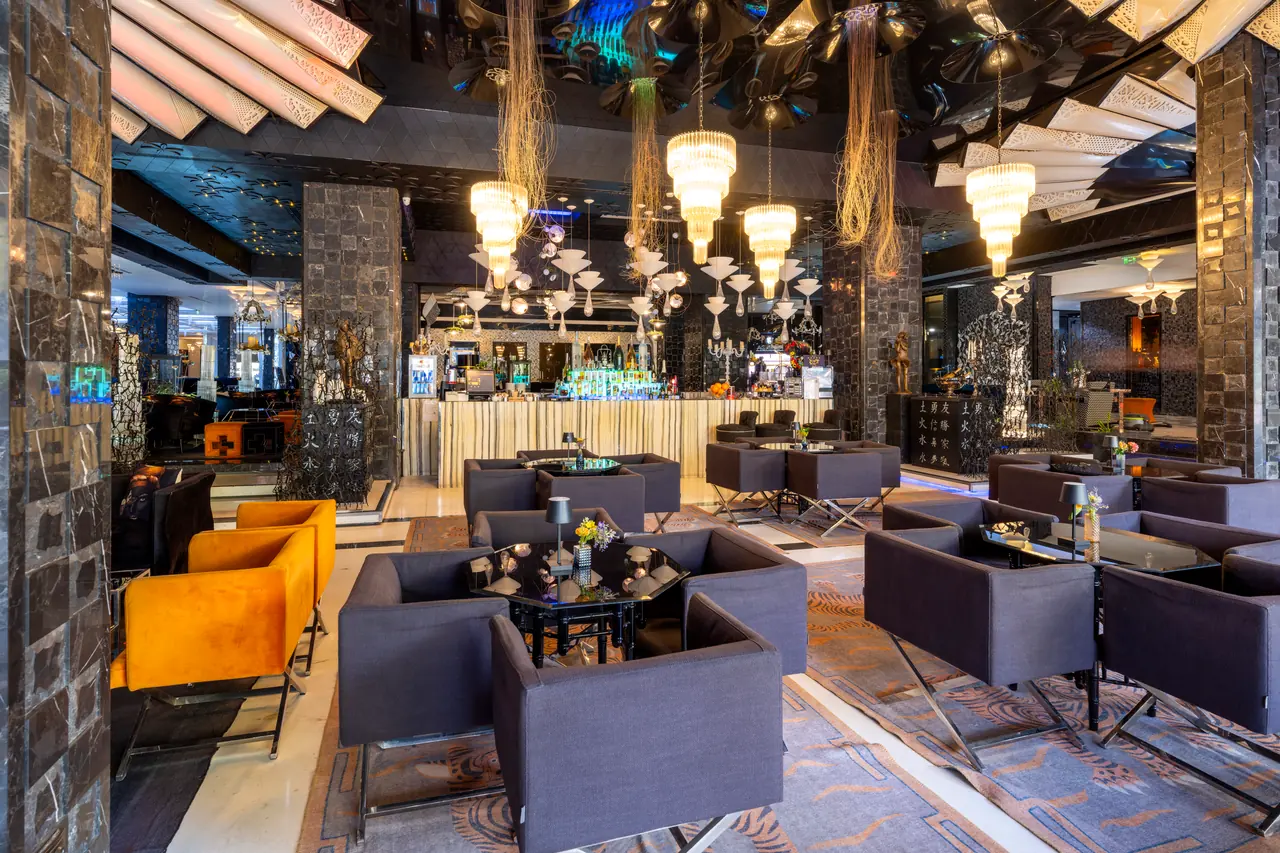 Zenith Casino by Merit International — Lobi barı: avizeler ve koyu oturma grupları